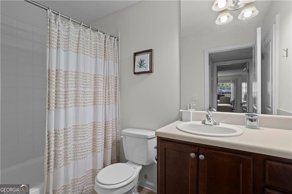 3650 Ashford Dunwoody Road Northeast, Unit 515 Atlanta, GA 30319 - Photo 10 of 14 a bathroom with a sink a toilet and shower curtain