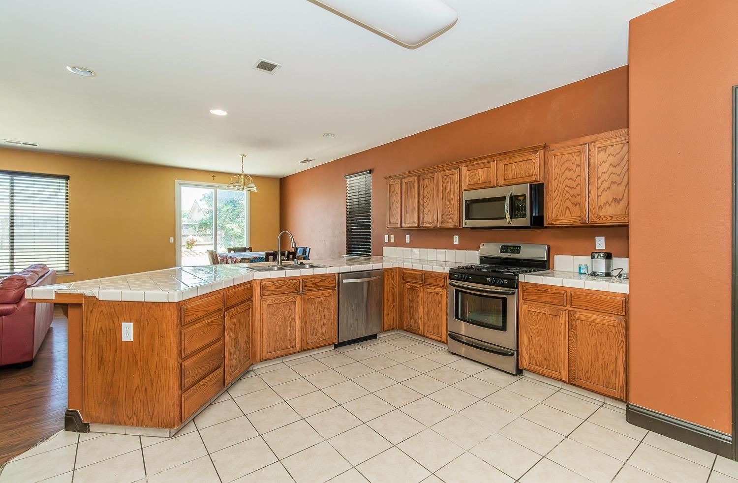 2666 Tammy Street Selma, CA 93662 - Photo 8 of 22 a kitchen with stainless steel appliances granite countertop a stove top oven a sink dishwasher and a refrigerator