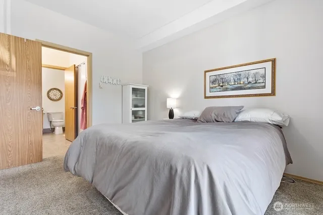 a bedroom with a bed and a painting on the wall