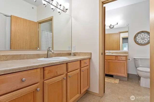 a bathroom with a sink a toilet and a mirror