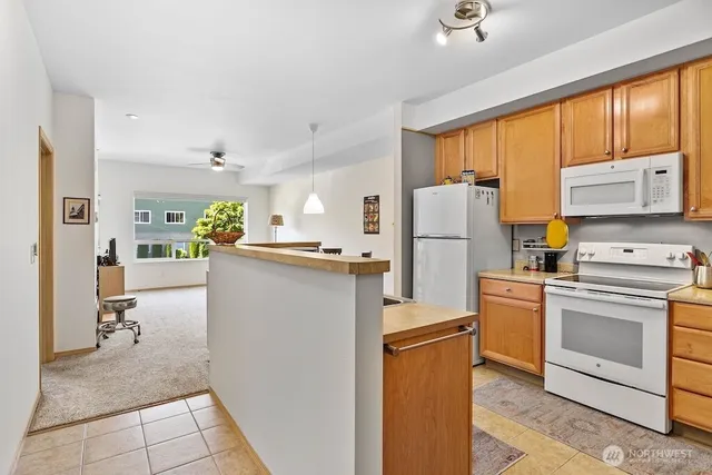 a kitchen with refrigerator cabinets and large window
