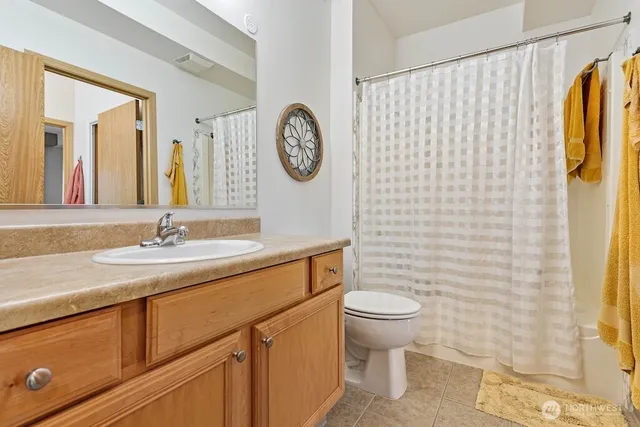 a bathroom with a granite countertop toilet sink and mirror