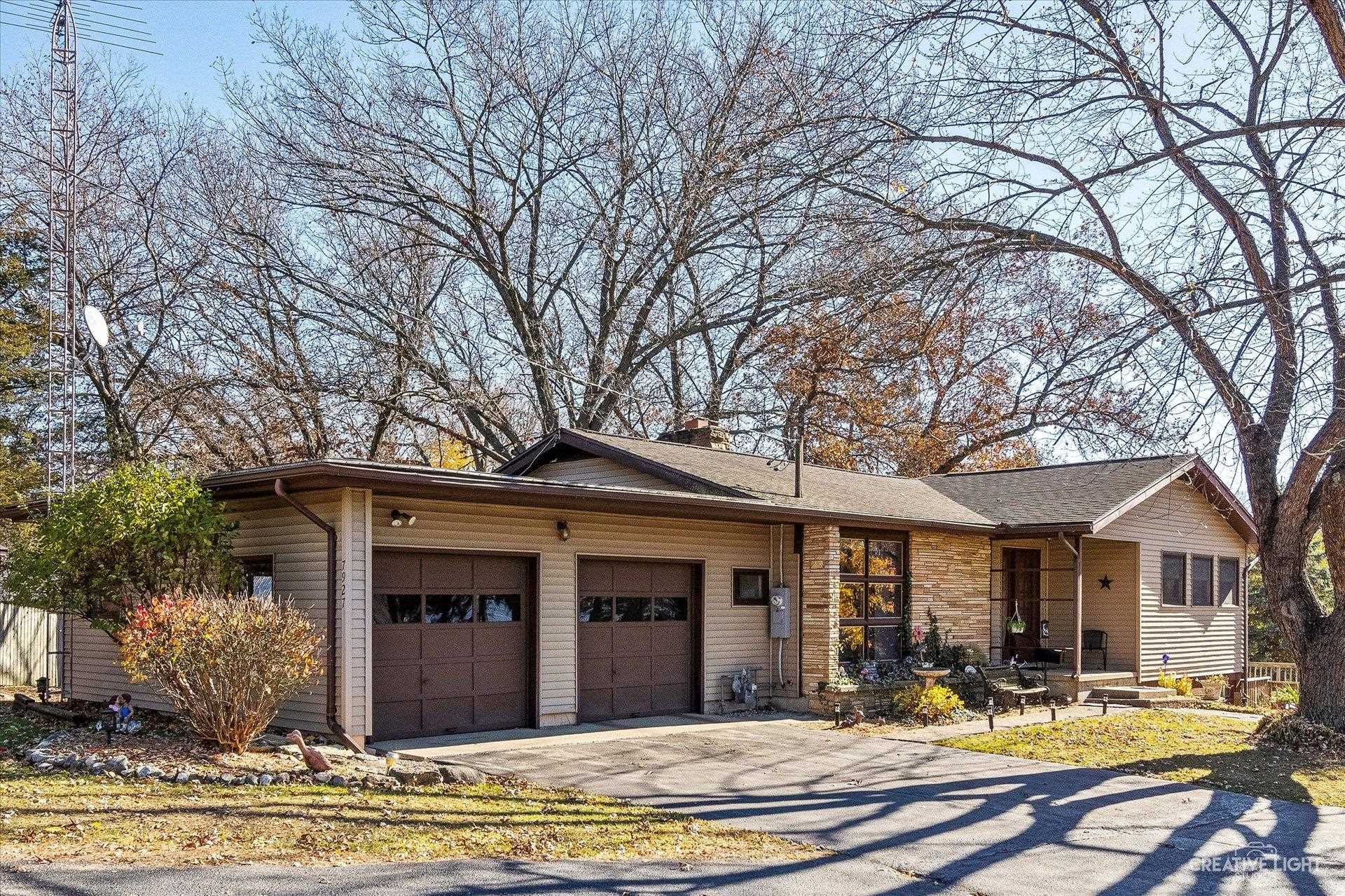 a view of a white house with large windows and a table and chairs in a patio