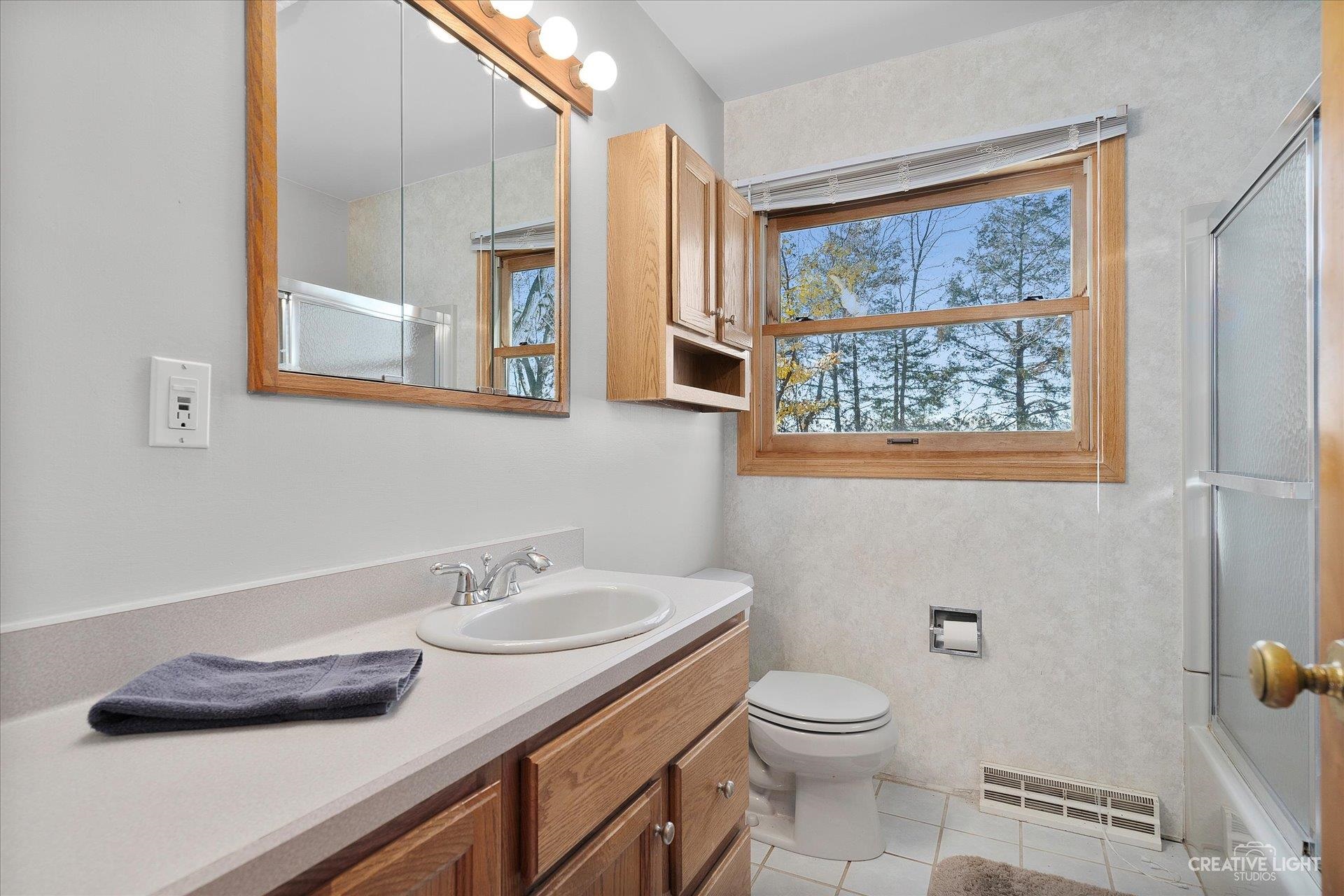 7927 Walnut Street Dixon, IL 61021 - Photo 14 of 33 a bathroom with a granite countertop sink and a toilet
