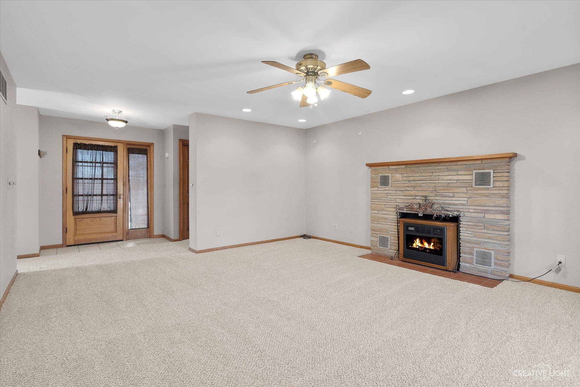 7927 Walnut Street Dixon, IL 61021 - Photo 5 of 33 an empty room with fireplace and fan
