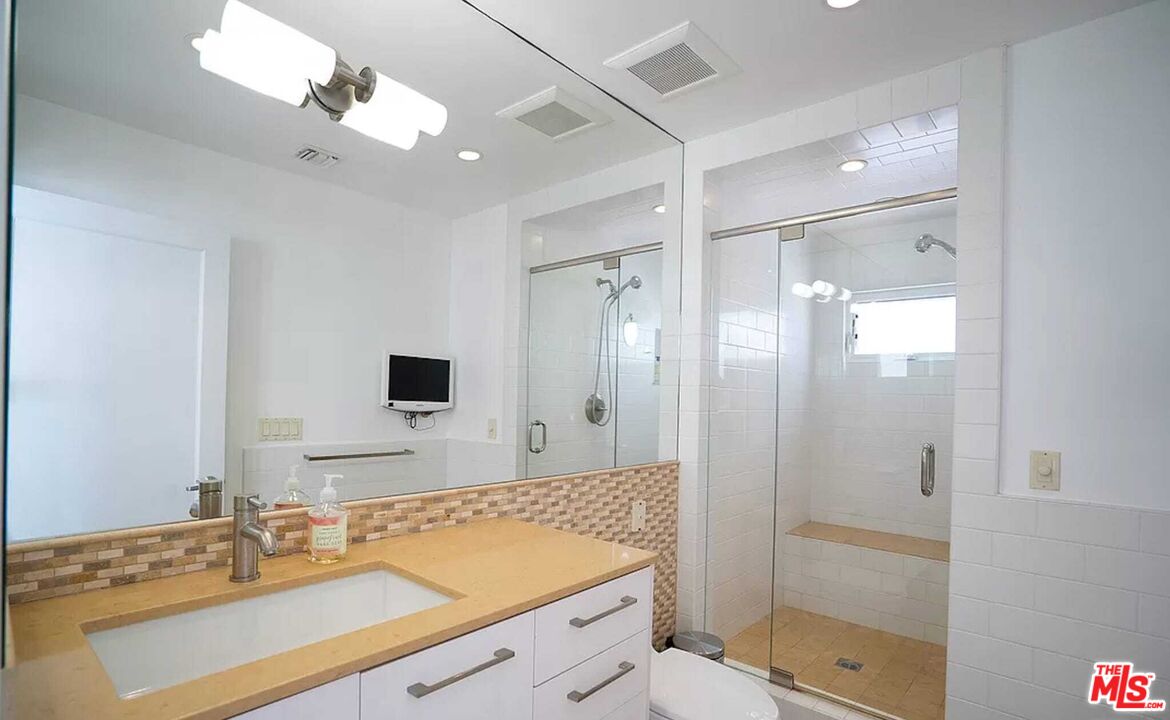 24742 Malibu Road Malibu, CA 90265 - Photo 12 of 18 a bathroom with a sink vanity granite shower and a mirror