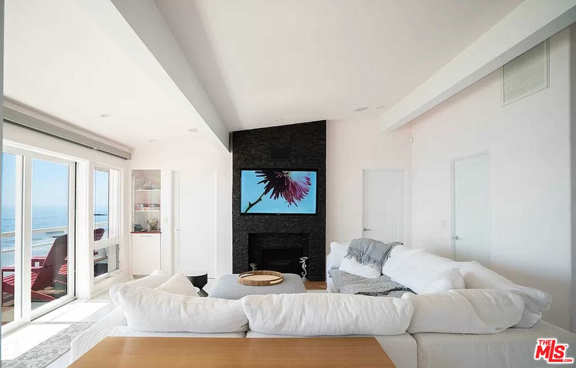 24742 Malibu Road Malibu, CA 90265 - Photo 18 of 18 a living room with furniture a fireplace and a flat screen tv