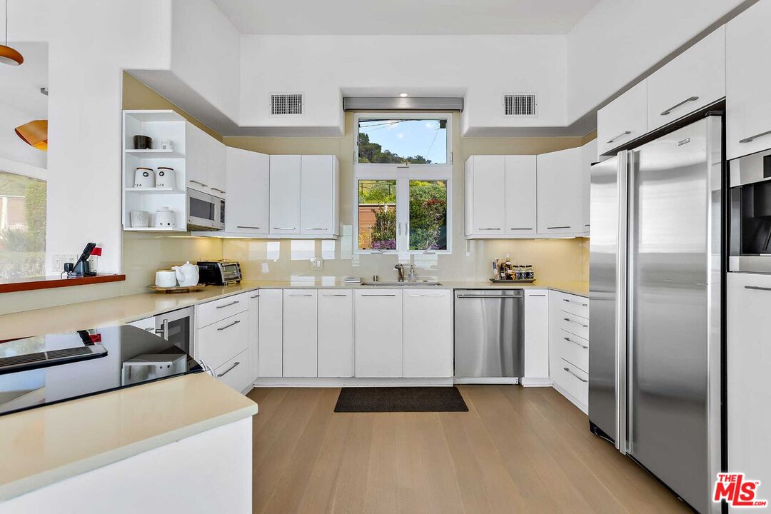 24742 Malibu Road Malibu, CA 90265 - Photo 6 of 18 a kitchen with white cabinets and white appliances