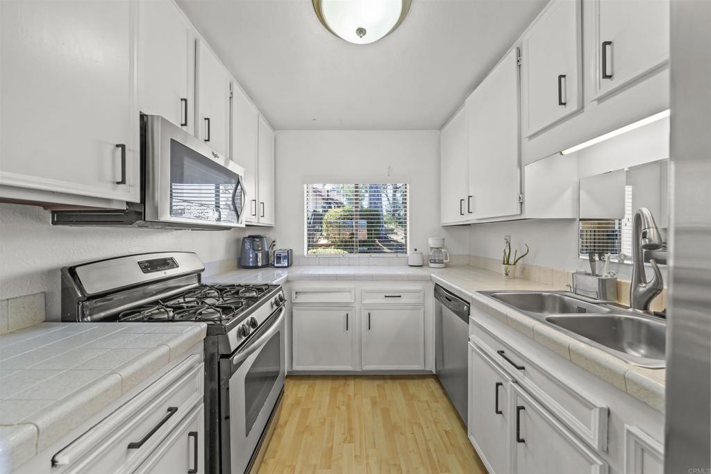 10775 Tamar Terrace, Unit A Santee, CA 92071 - Photo 33 of 38 a kitchen with stainless steel appliances granite countertop a sink stove cabinets and a refrigerator