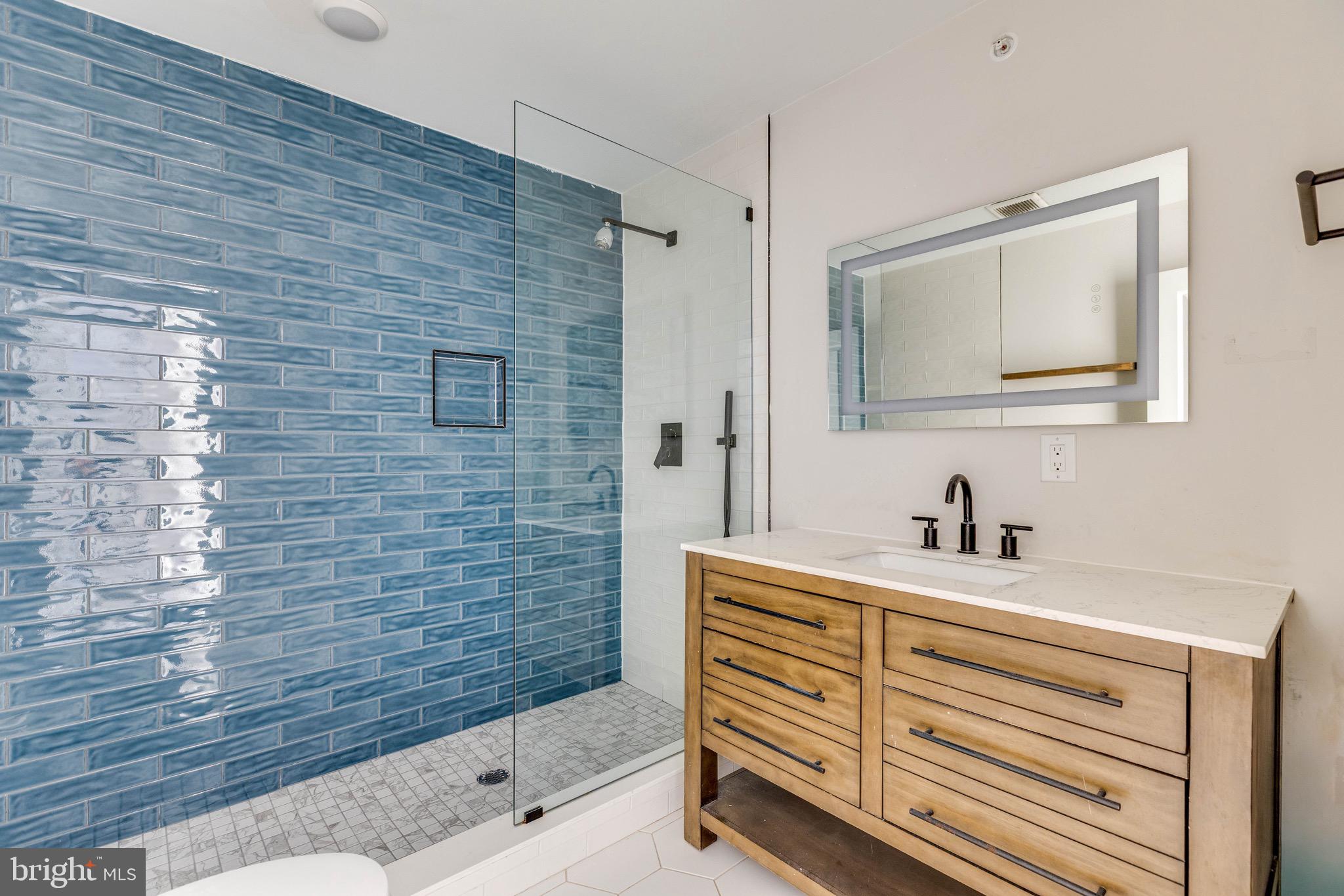 1535 North 6th Street, Unit E Philadelphia, PA 19122 - Photo 6 of 11 a bathroom with a sink a mirror and shower