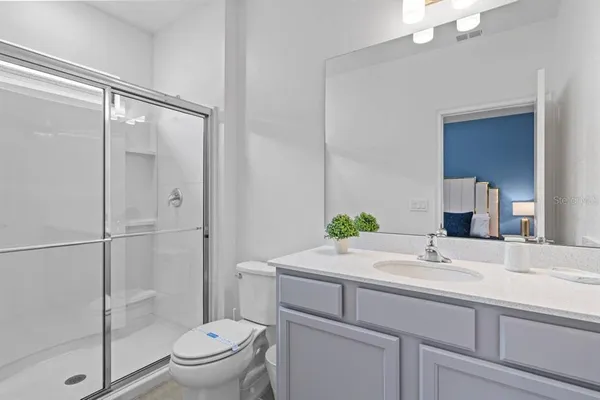 a bathroom with a sink mirror toilet and shower