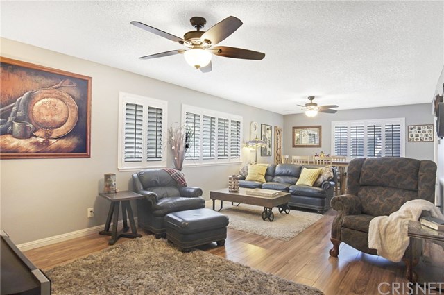 Living room and dining area with new hardwood floors, plantation shutters and ceiling fans
