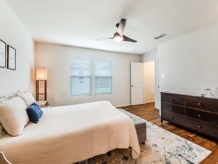 a bedroom with a large bed and a wooden floor