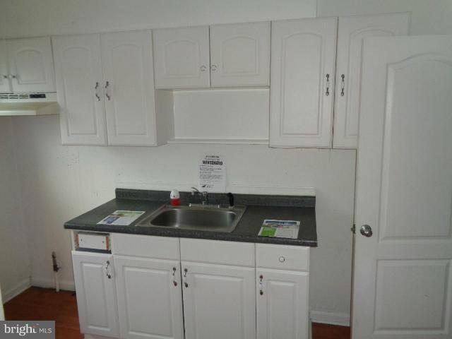 336 Stemmers Run Road Baltimore, MD 21221 - Photo 7 of 13 a kitchen with white cabinets and a sink
