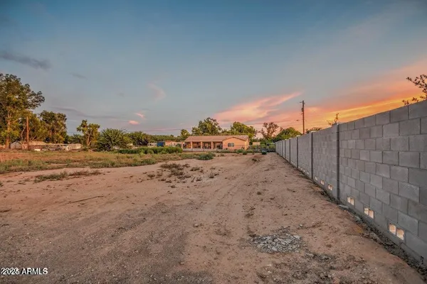 a view of a dry yard with wooden fence