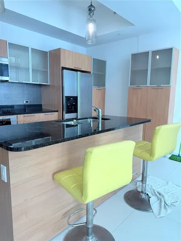 a kitchen with stainless steel appliances granite countertop a refrigerator and a stove