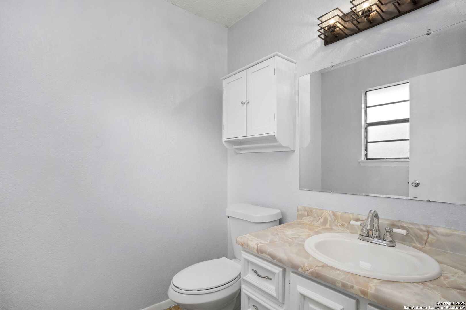 127 Harless Way Center Point, TX 78010 - Photo 20 of 25 a bathroom with a granite countertop sink a toilet and mirror