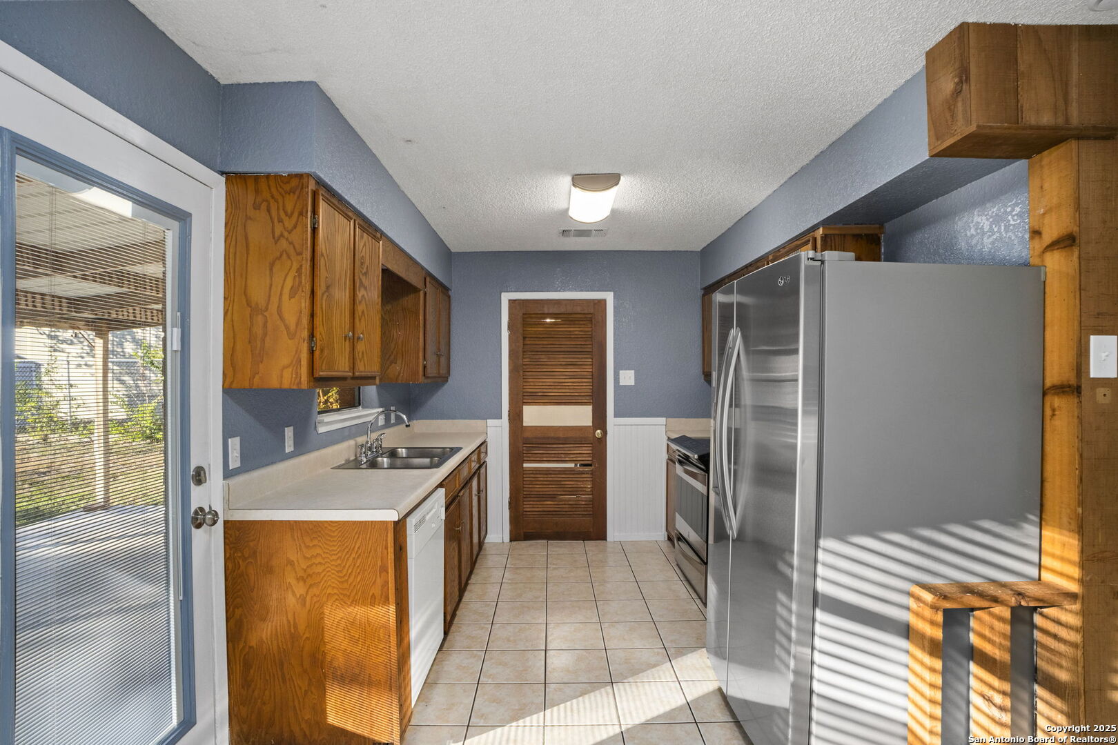 127 Harless Way Center Point, TX 78010 - Photo 9 of 25 a kitchen with a refrigerator a stove top oven and a large window