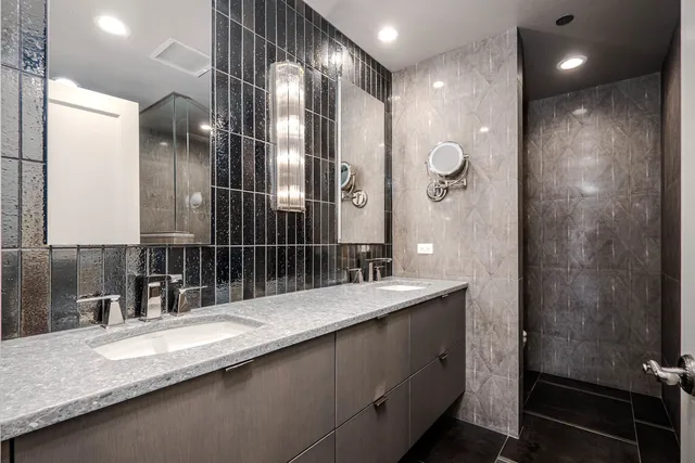 a bathroom with a granite countertop sink a mirror and a shower