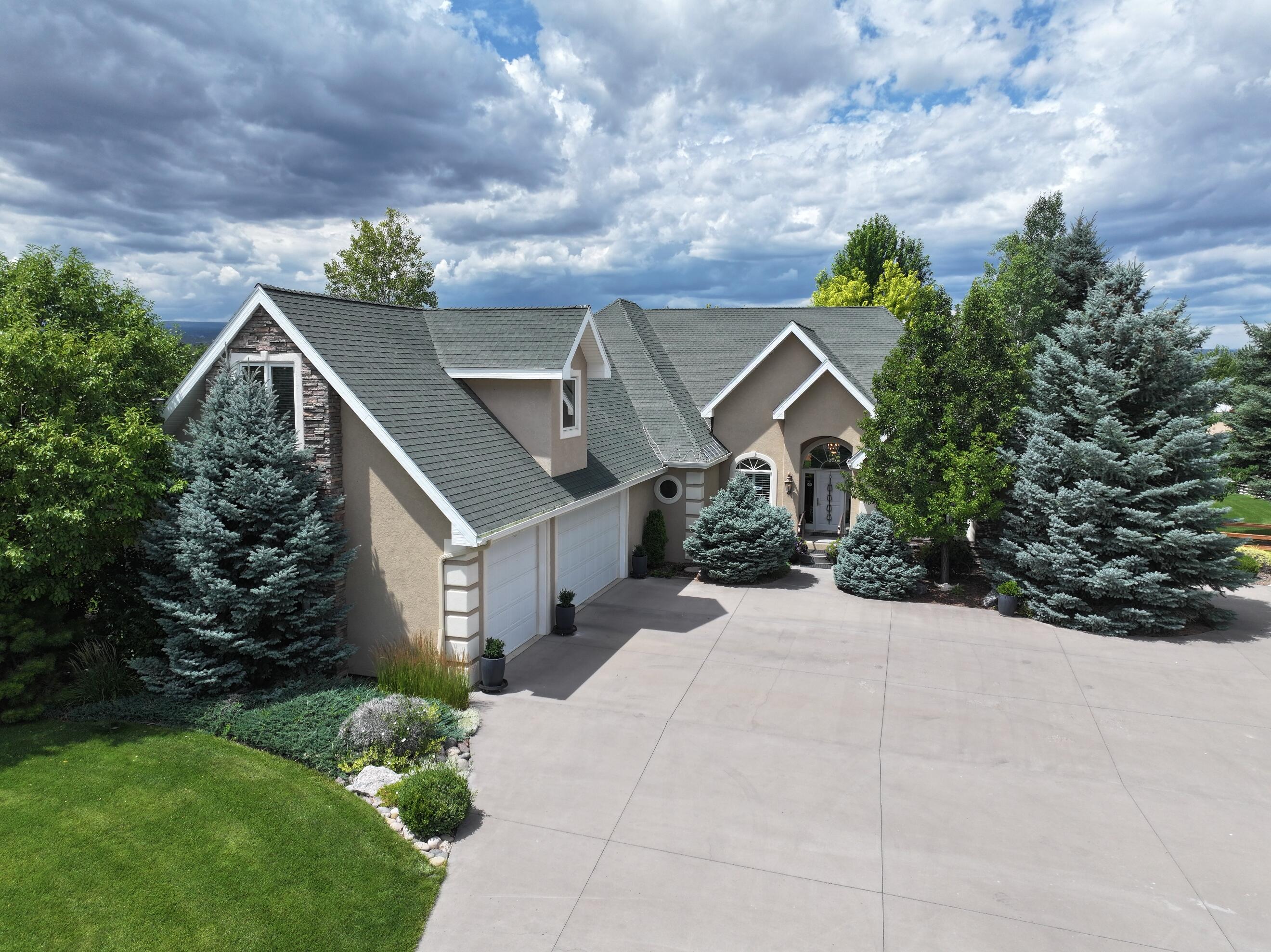 15103 6260th Road Montrose, CO 81403 - Photo 2 of 54 a front view of a house with a yard and potted plants