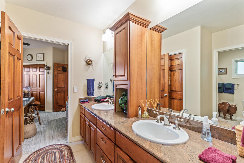 15103 6260th Road Montrose, CO 81403 - Photo 32 of 54 a bathroom with a granite countertop sink and a mirror