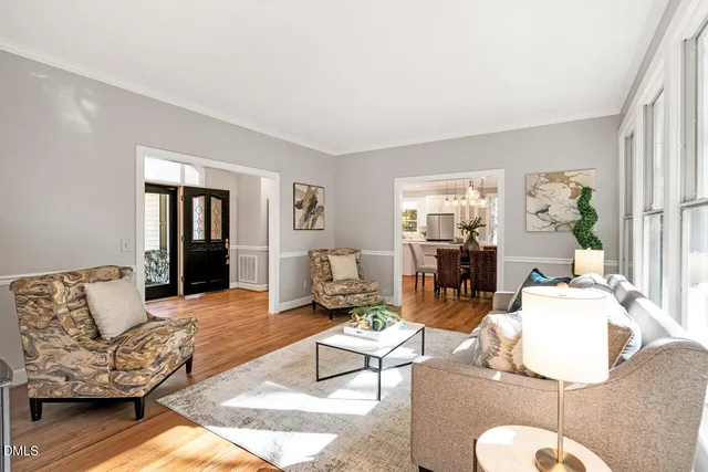 a view of a dining room with furniture a chandelier and wooden floor