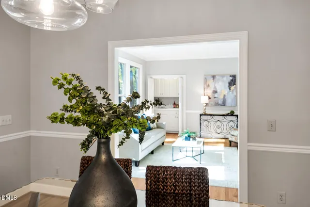a dining room with furniture a chandelier and wooden floor