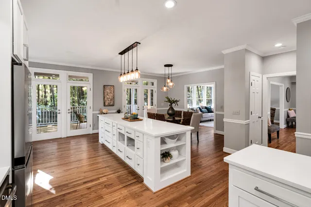 a large white kitchen with sink a counter top space and stainless steel appliances