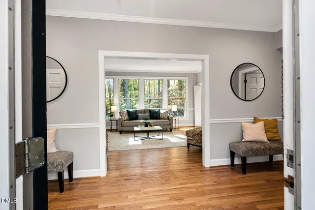 a living room with furniture a rug a lamp and a large window