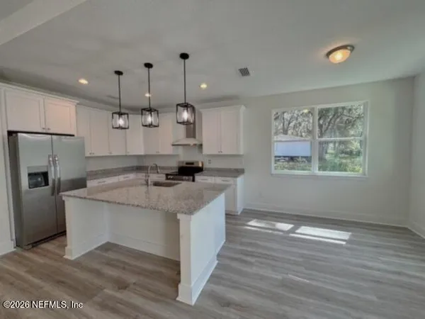 a kitchen with a counter top space a sink stainless steel appliances and cabinets