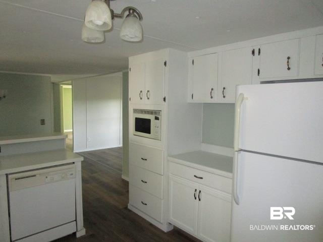 14791 Raber Road Summerdale, AL 36580 - Photo 9 of 21 Kitchen featuring white appliances, dark hardwood / wood-style floors, and white cabinetry