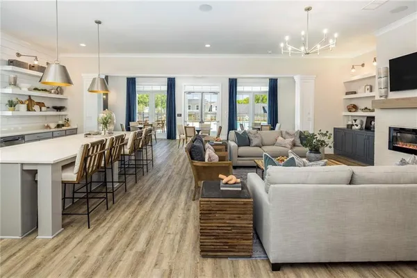a living room with furniture a fireplace and a chandelier