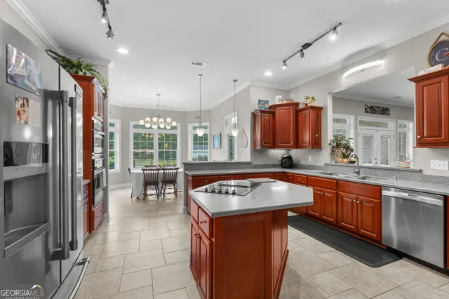 a kitchen with stainless steel appliances granite countertop a sink a stove and a refrigerator