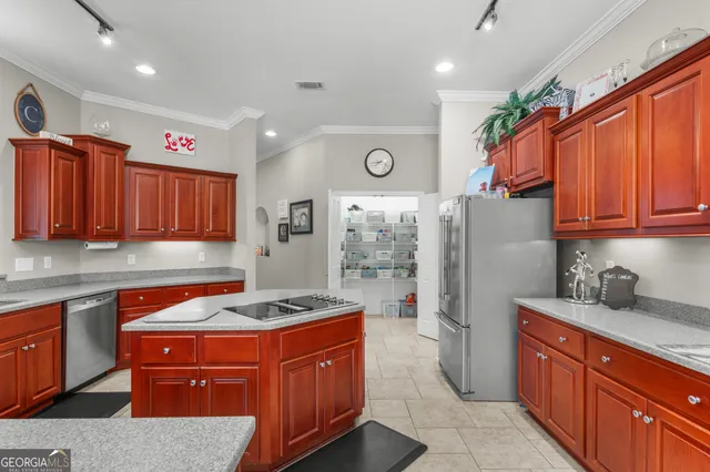 a kitchen with stainless steel appliances granite countertop a refrigerator a sink and wooden cabinets