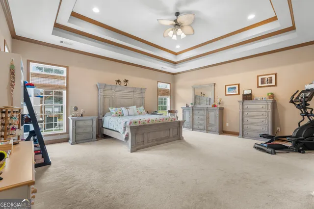 a spacious bedroom with a bed a couch and dresser