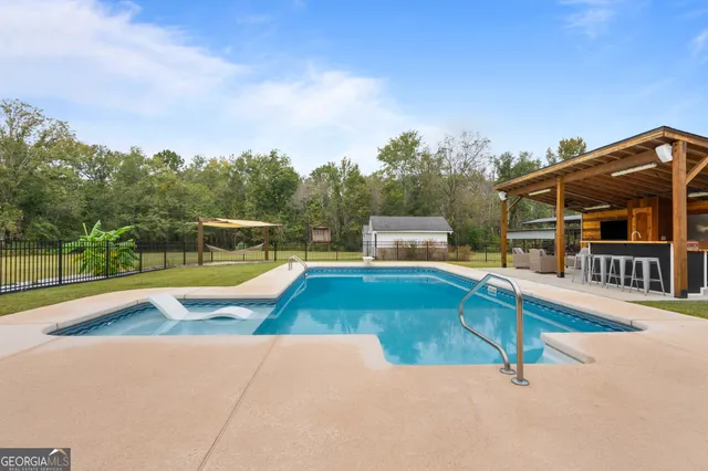 a house view with swimming pool in front of it