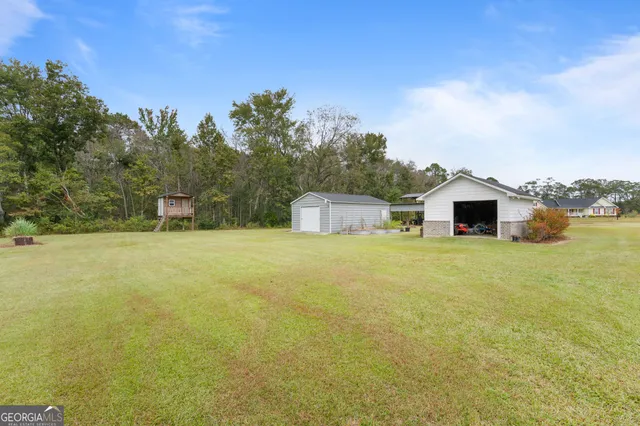 an aerial view of a house with a yard and tree s