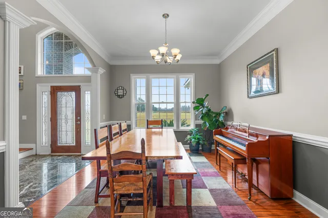 a living room with furniture a dining table and a chandelier