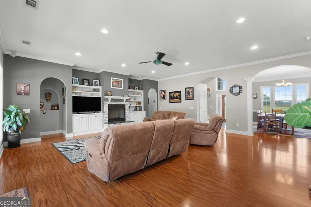 a living room with furniture fireplace and wooden floor