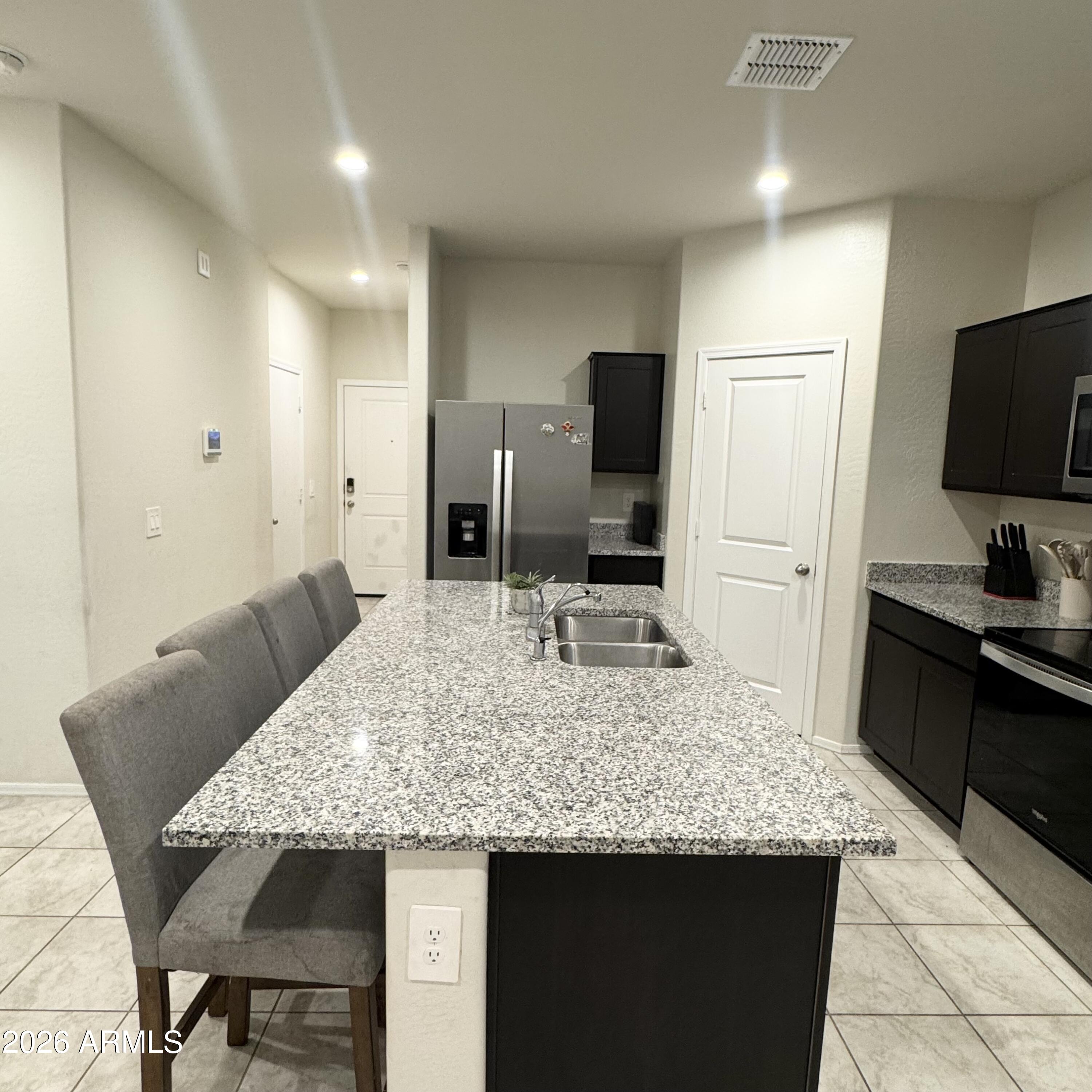 5208 East Emery Road San Tan Valley, AZ 85143 - Photo 3 of 30 a kitchen with granite countertop kitchen island cabinets and refrigerator