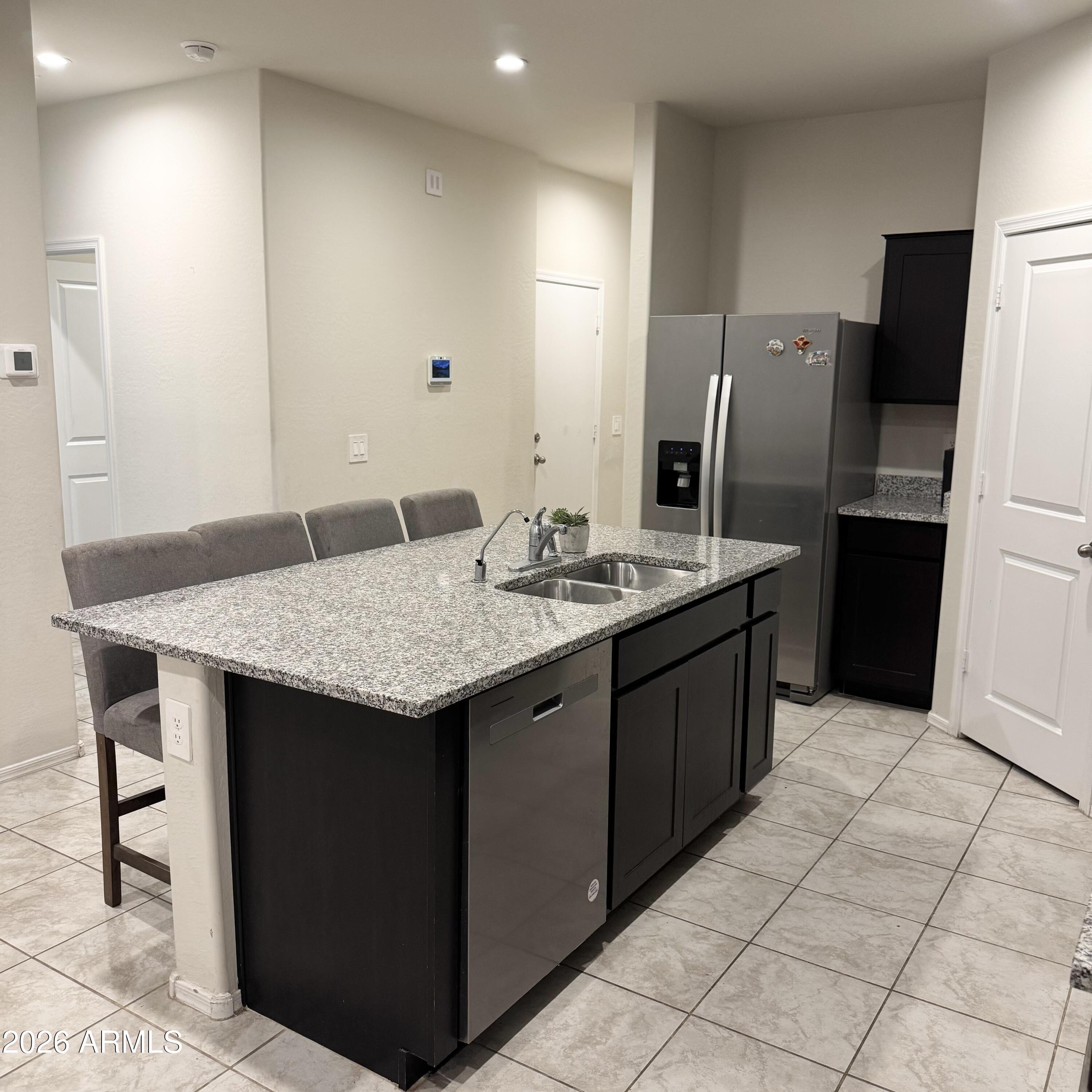 5208 East Emery Road San Tan Valley, AZ 85143 - Photo 6 of 30 a kitchen with a sink a refrigerator and wooden cabinets
