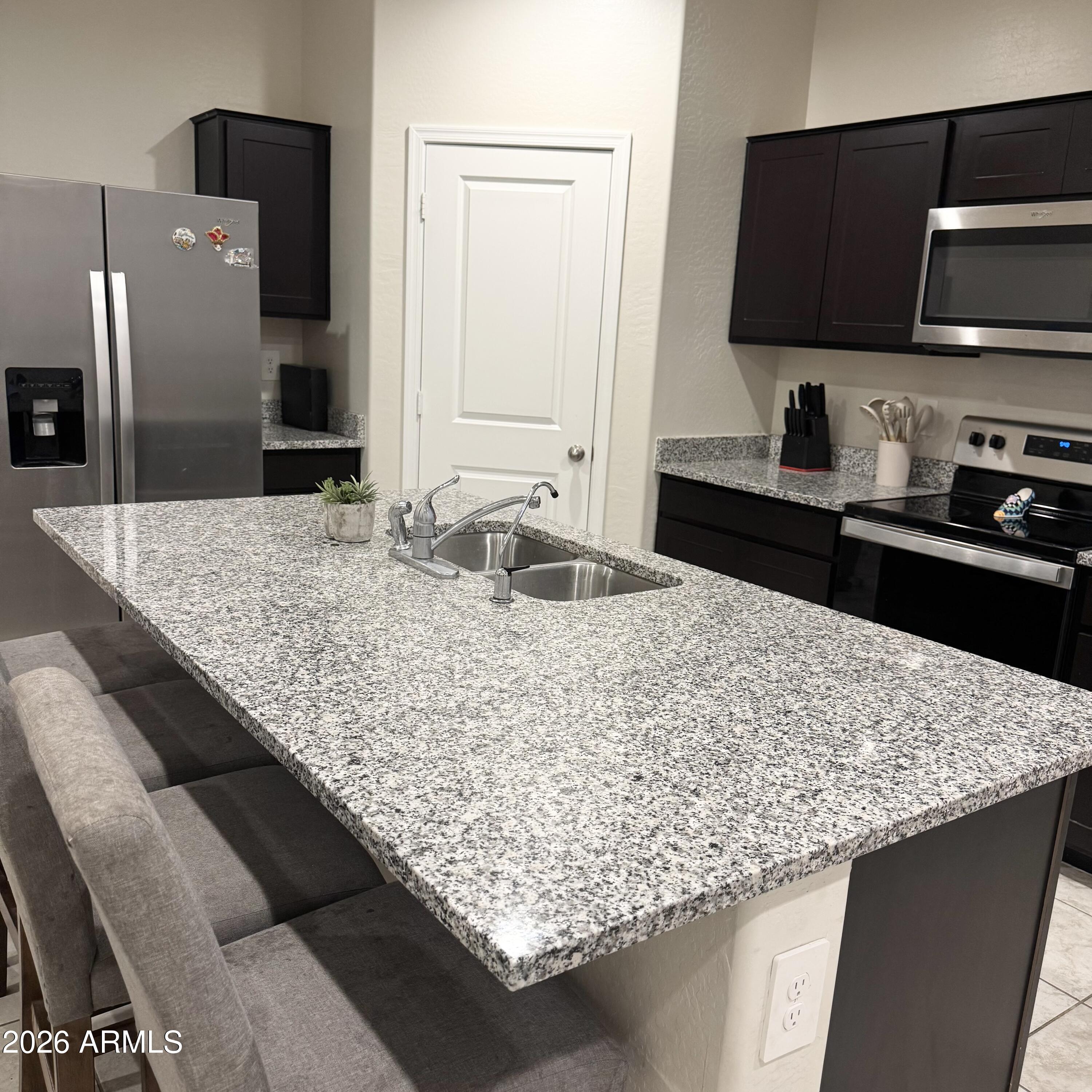 5208 East Emery Road San Tan Valley, AZ 85143 - Photo 9 of 30 a kitchen with granite countertop counter top space cabinets and stainless steel appliances