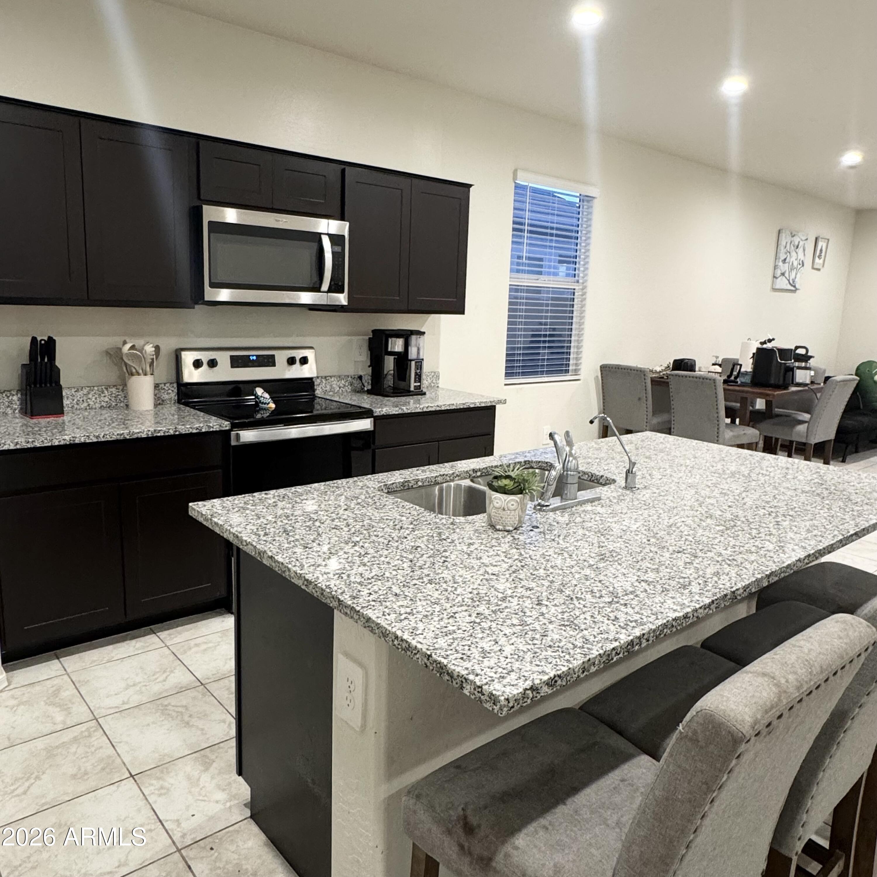 5208 East Emery Road San Tan Valley, AZ 85143 - Photo 10 of 30 a kitchen with kitchen island granite countertop a sink counter top space appliances and cabinets