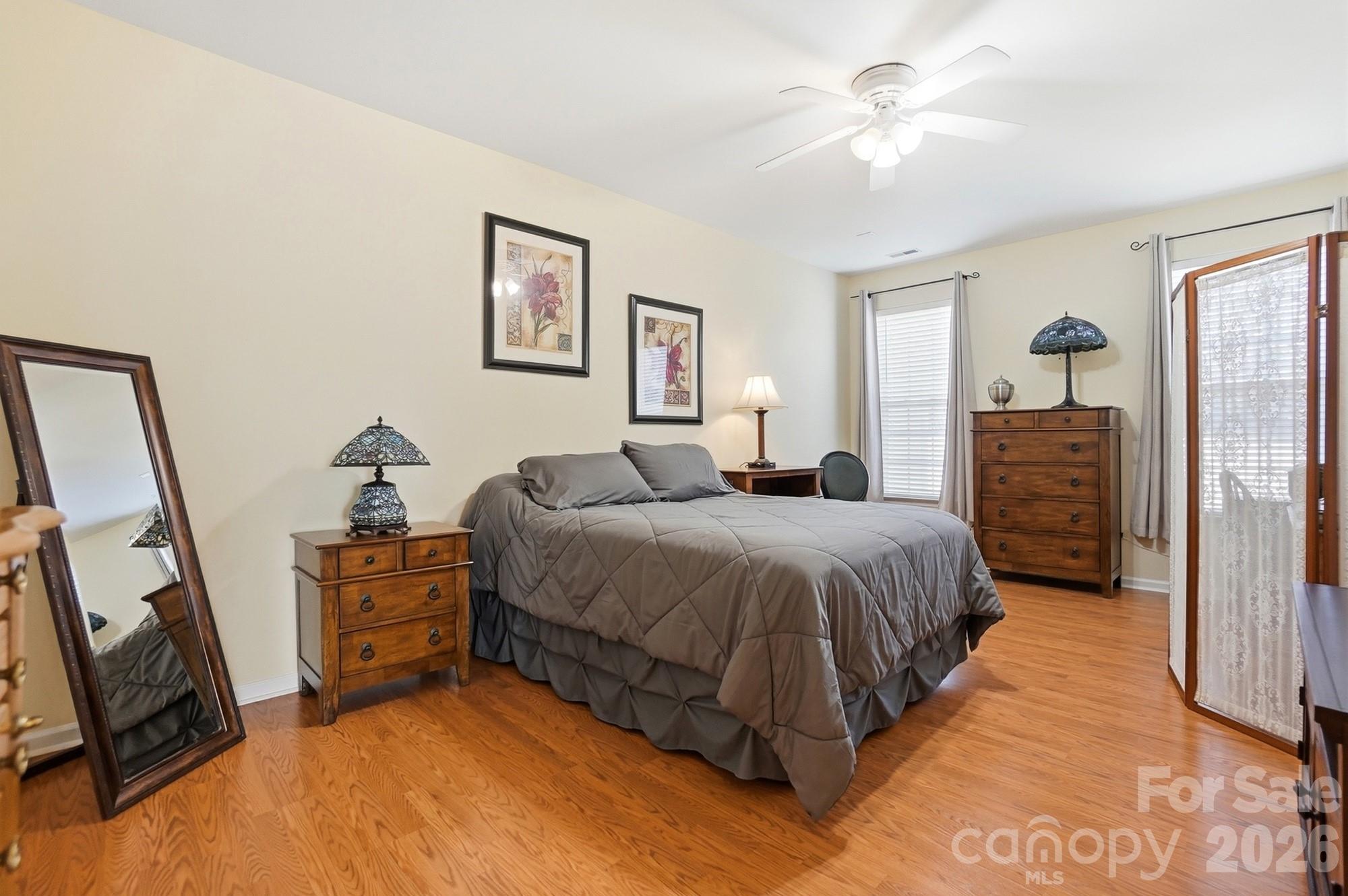 1667 Onyx Ridge Fort Mill, SC 29708 - Photo 16 of 25 a spacious bedroom with a bed a dresser and a chandelier
