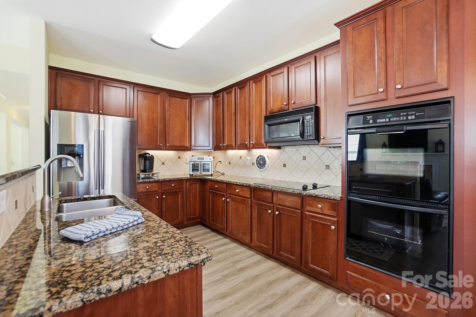 1667 Onyx Ridge Fort Mill, SC 29708 - Photo 7 of 25 a kitchen with stainless steel appliances granite countertop a refrigerator stove top oven and sink