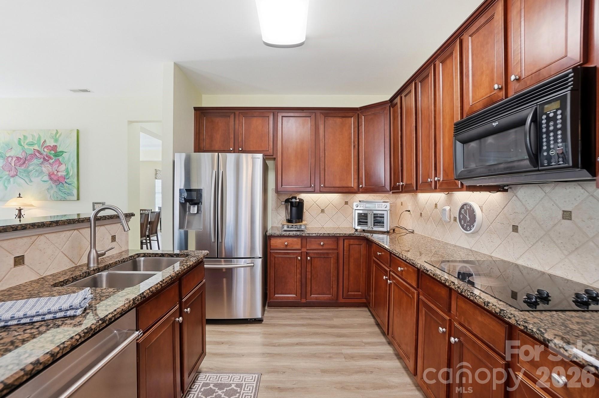 1667 Onyx Ridge Fort Mill, SC 29708 - Photo 8 of 25 a kitchen with stainless steel appliances granite countertop a sink stove refrigerator and cabinets