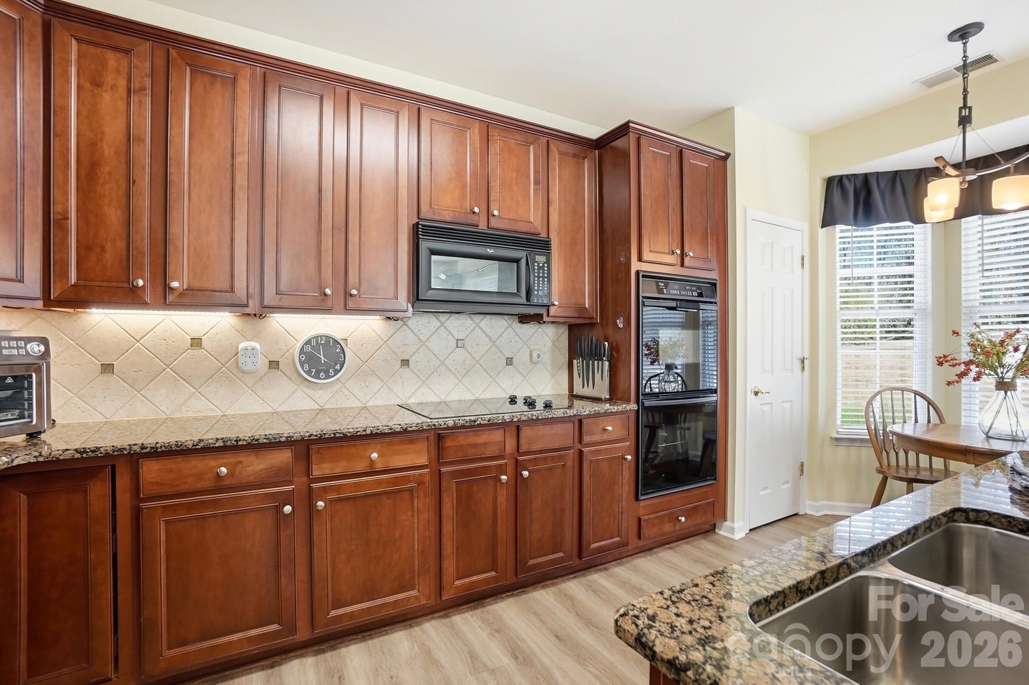 1667 Onyx Ridge Fort Mill, SC 29708 - Photo 10 of 25 a kitchen with granite countertop wooden cabinets a sink and a stove