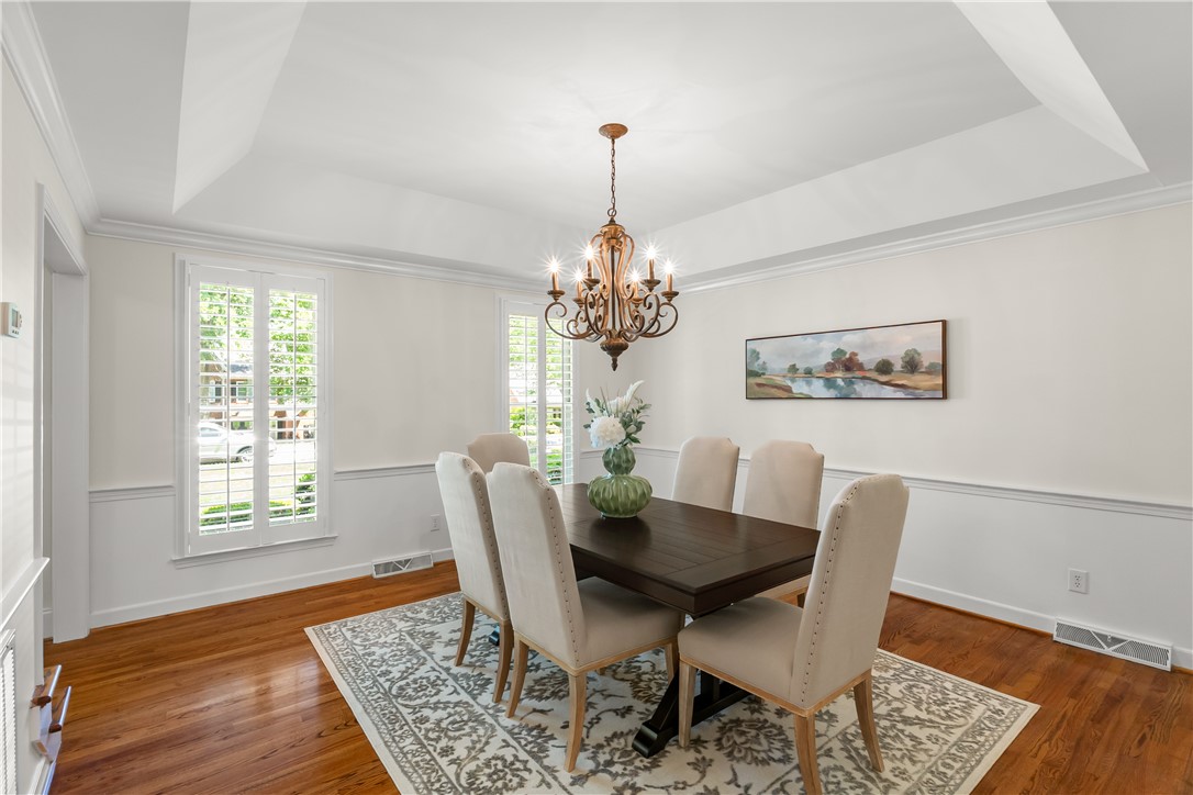 312 English Oak Road Simpsonville, SC 29681 - Photo 12 of 48 Elegant dining space featuring rich wood flooring and classic window shutters for a refined ambiance.