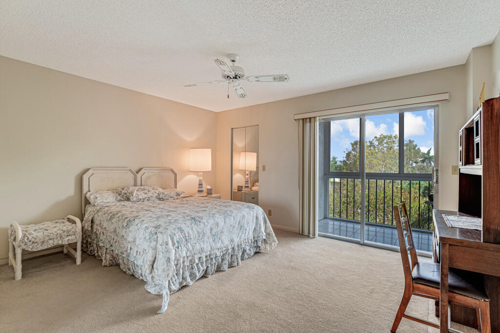 7301 Amberly Lane, Unit 407 Delray Beach, FL 33446 - Photo 13 of 23 a bedroom with bed and a large window