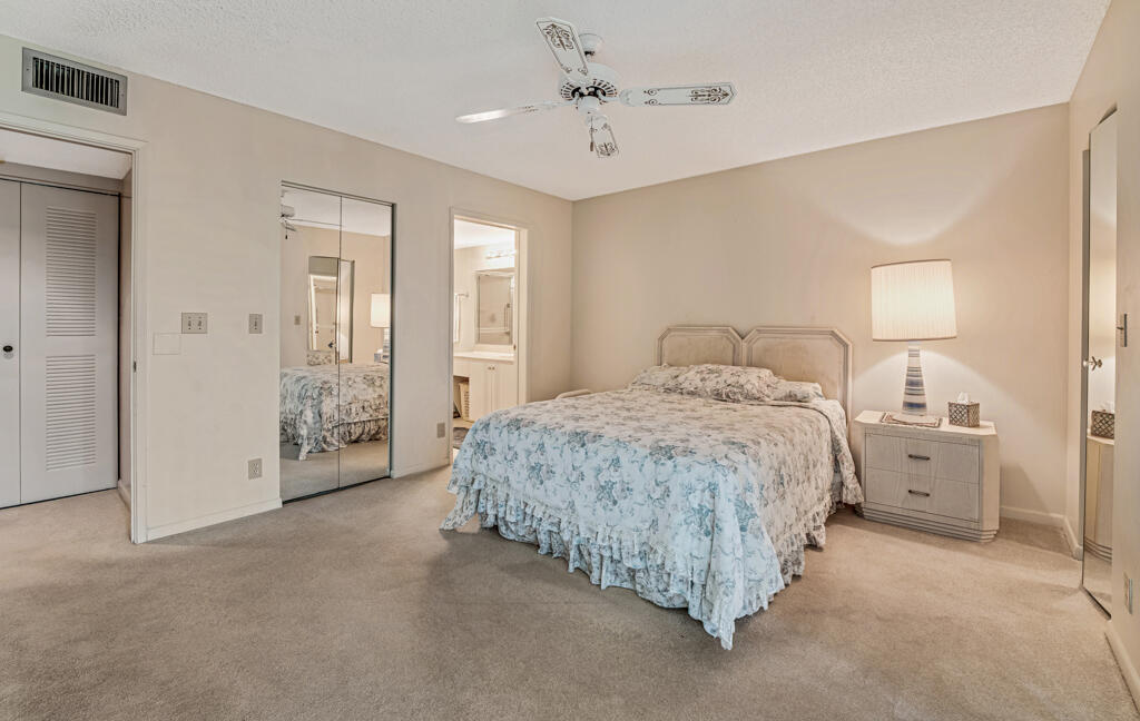 7301 Amberly Lane, Unit 407 Delray Beach, FL 33446 - Photo 14 of 23 a spacious bedroom with a bed and closet
